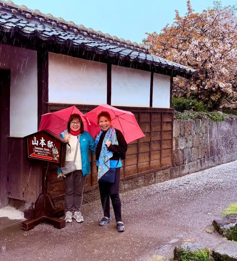 Two women standing outside in rain in rural Japan