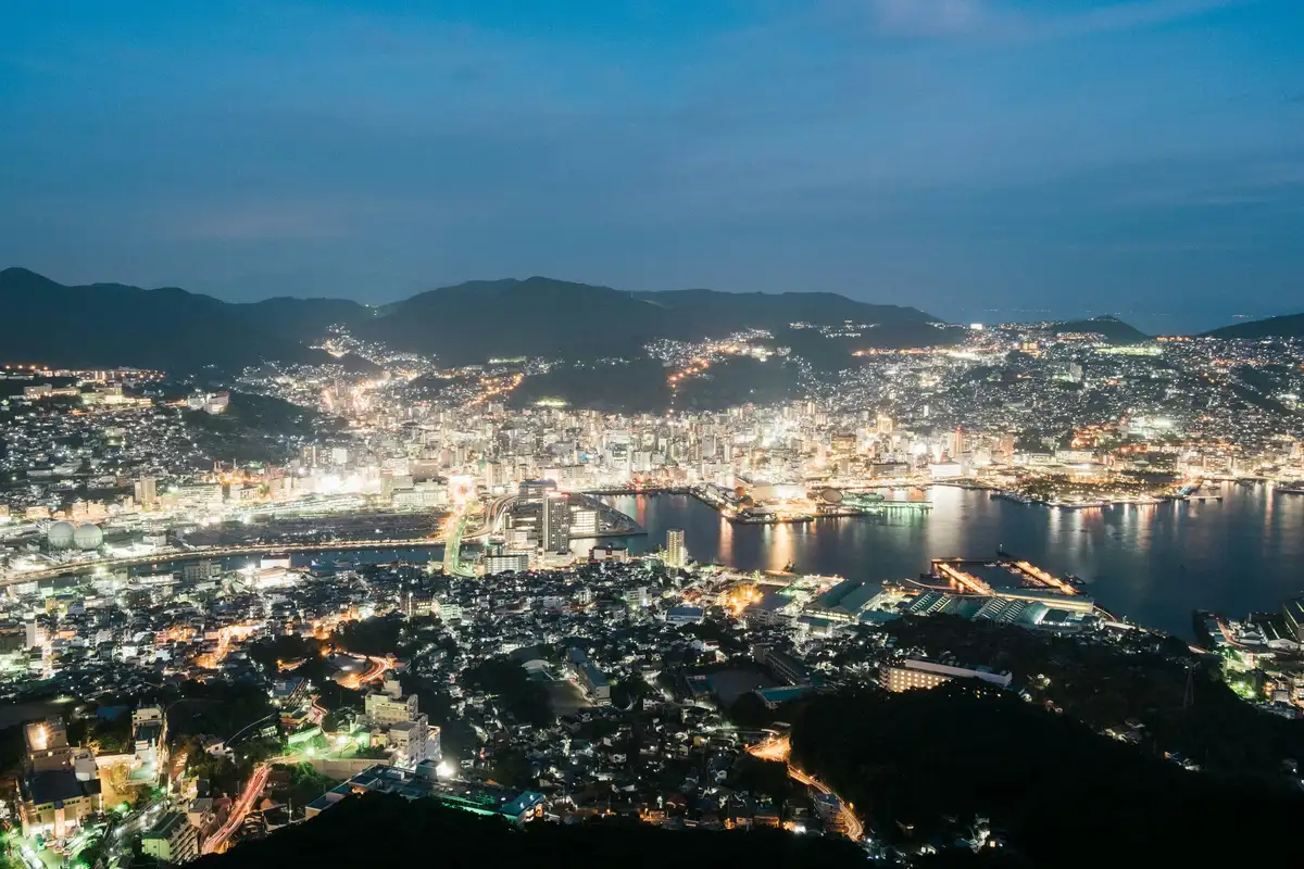 An ocean ferry ride, volcanic ruins, vibrant Nagasaki, and a mountaintop ropeway nightscape.