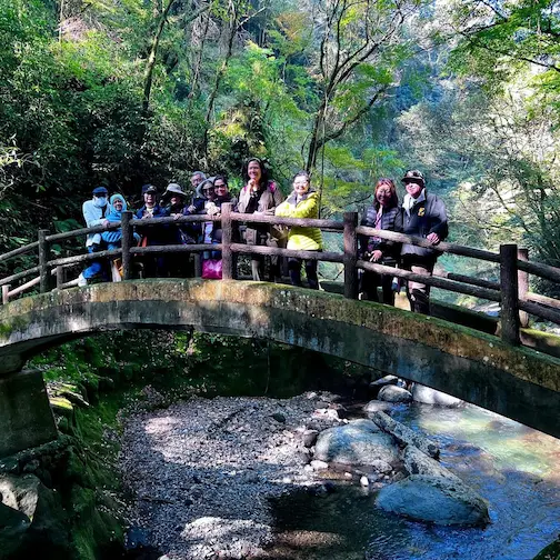Group tour posing for a photo on a bridge near Amano Iwata shrine in Miyazaki