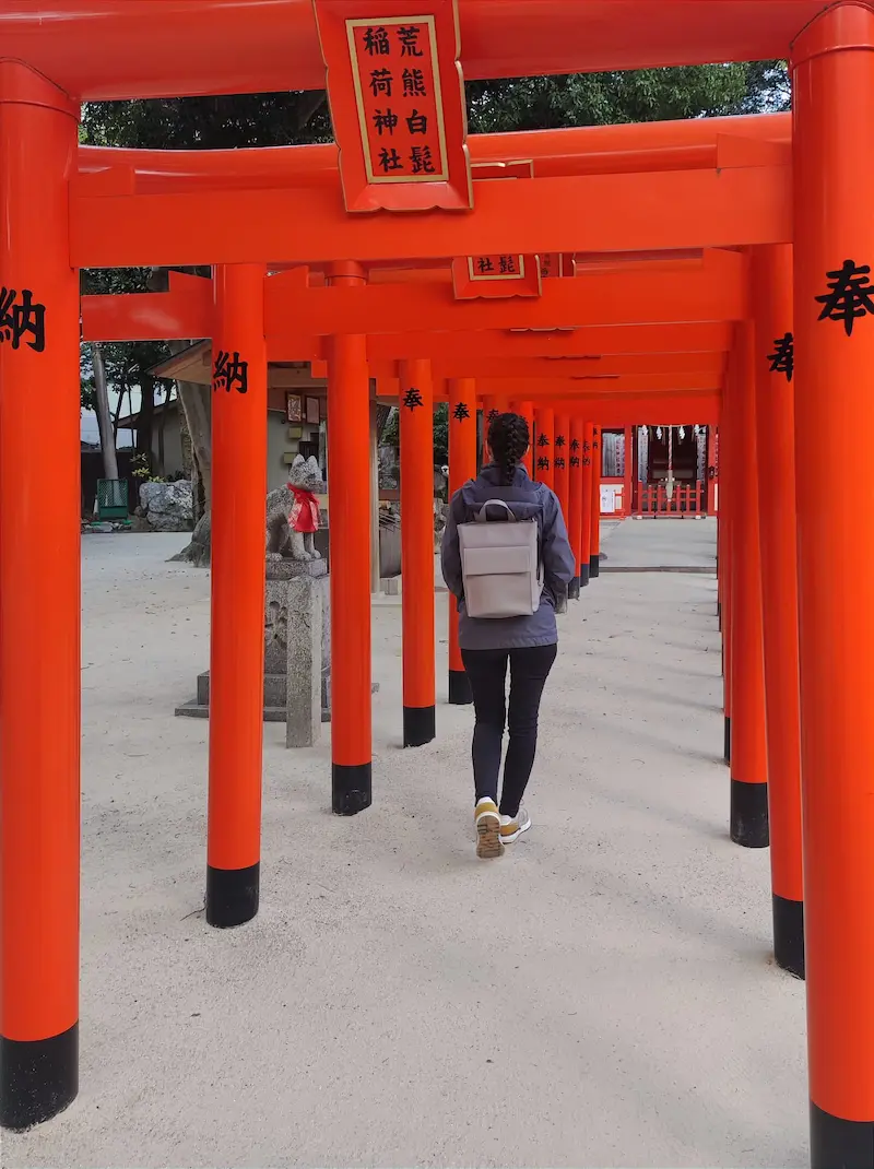 Woman walking through Torii gates at Sumiyoshi Shrine in Hakata