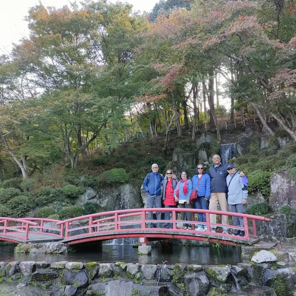 A family stopping for a photo on a bridge during a tour of Kyushu