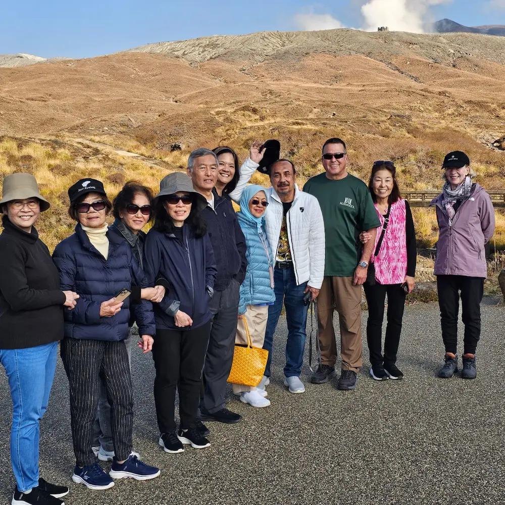 From the Autmn Tour in 2024, a group of tourist stop for a photo beneath Aso